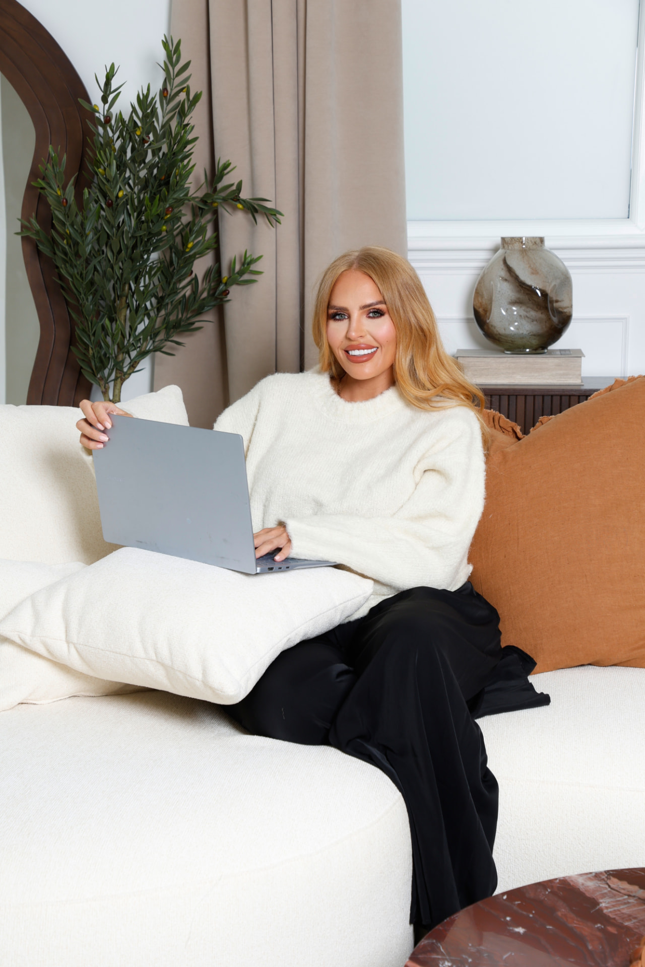 Sophia relaxed on the sofa with her laptop